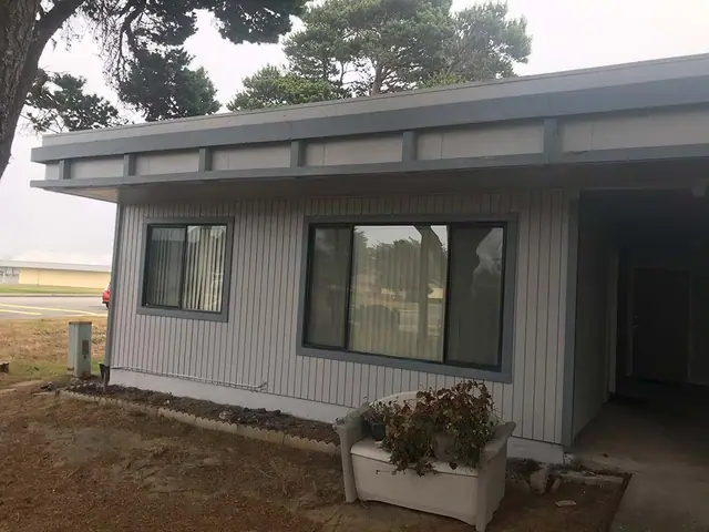 Single-story building, gray siding and trim