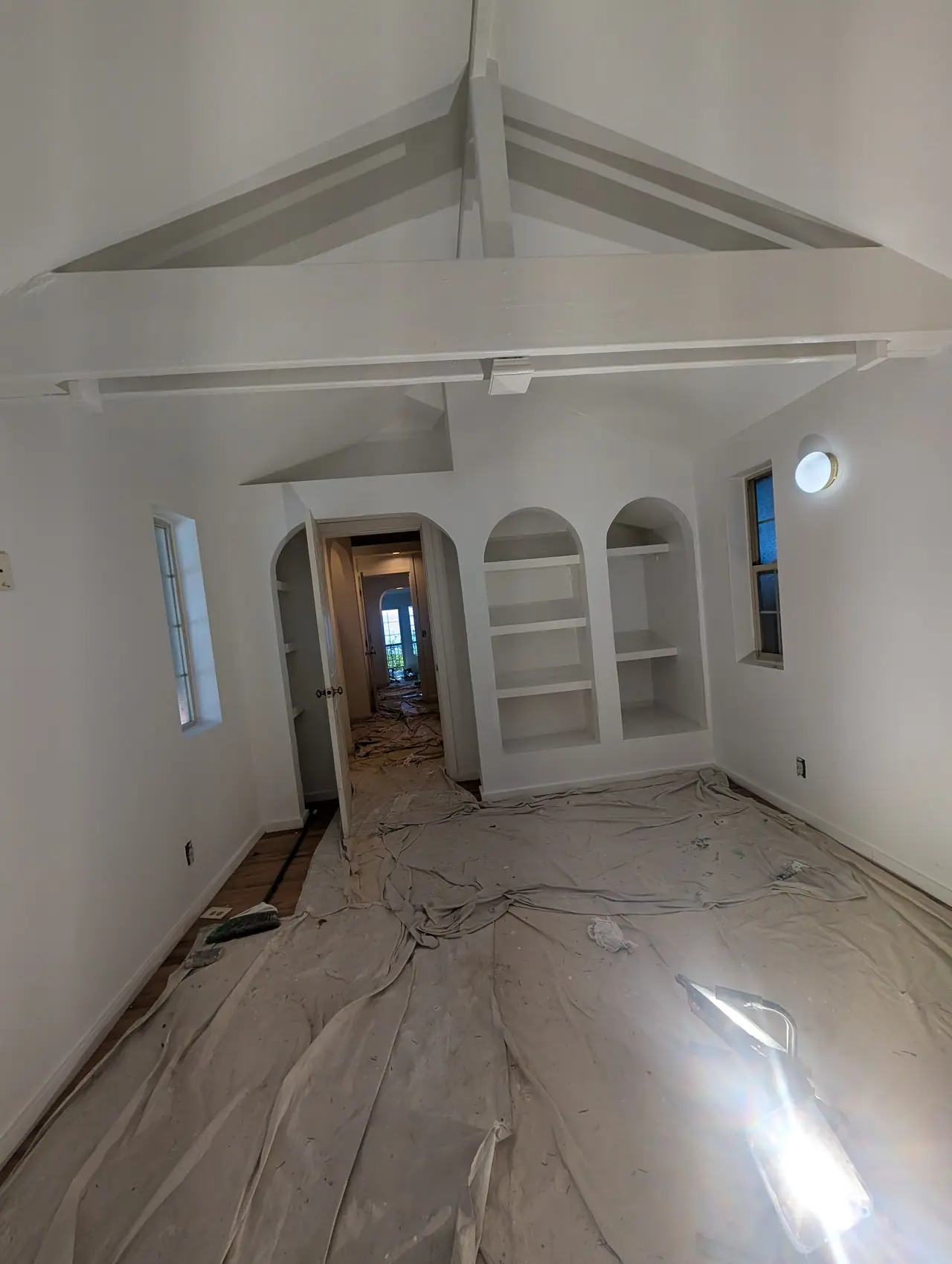 The cottage's white room with arched built-in shelves, before the color