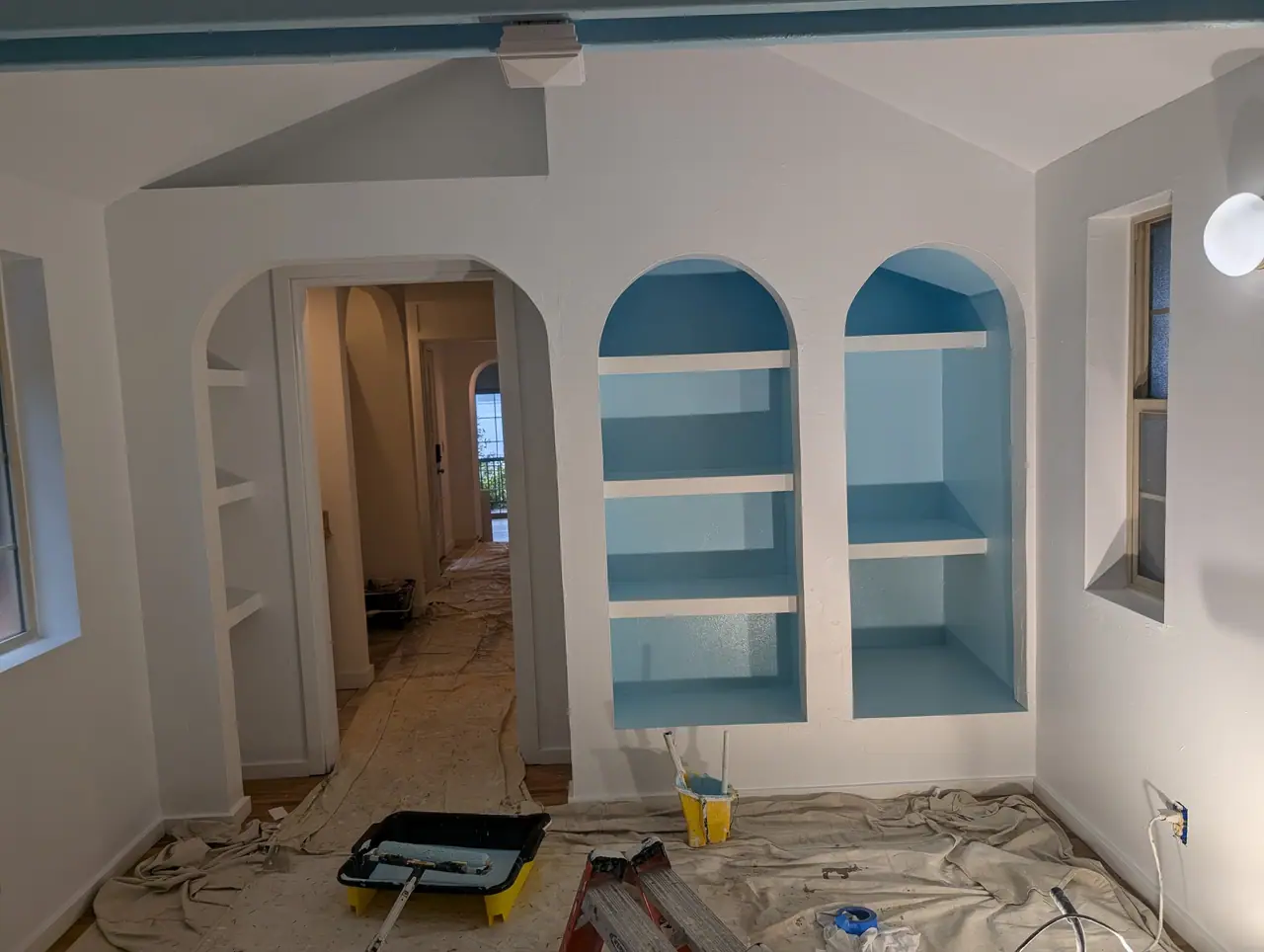 The same arched built-in shelves, painted blue inside and white around