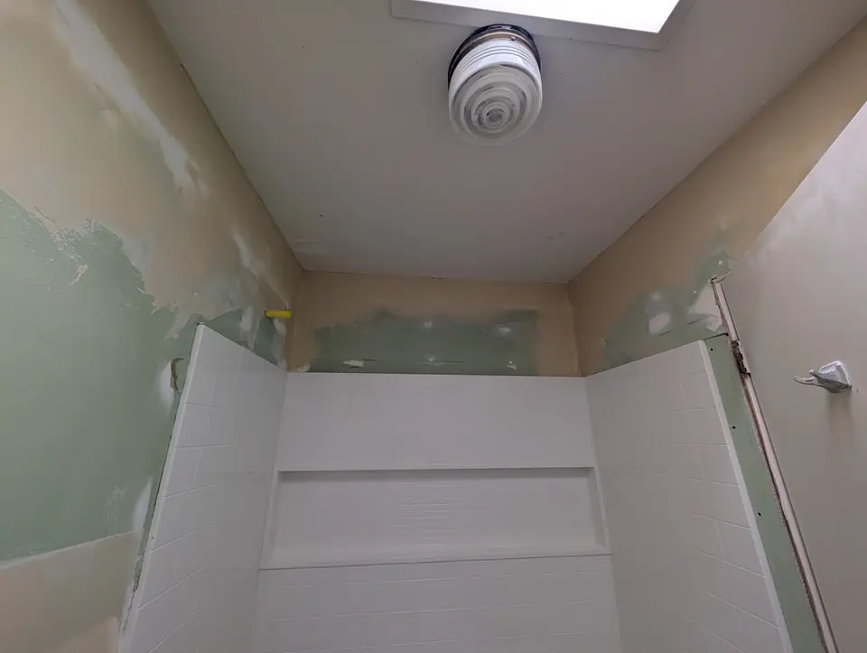 A new tub surround in a bathroom, fresh mud on the walls around it