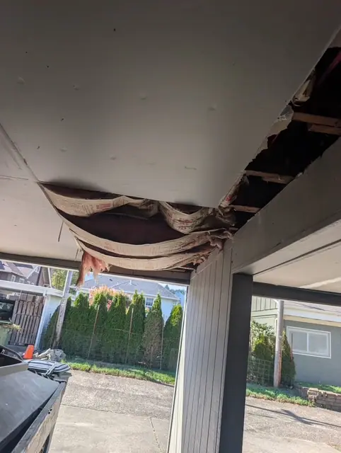 Before: a carport ceiling sagging open, torn insulation hanging down